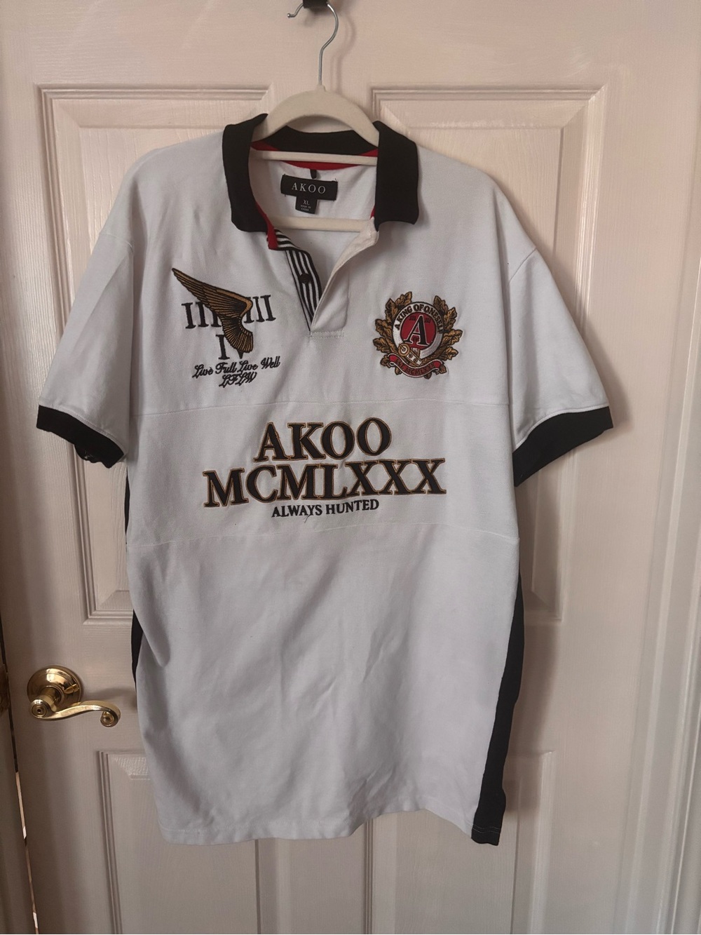 AKOO White Polo with Black Trim and Gold Embroidered Crest